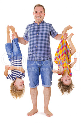 Father holding his smiling children upside down