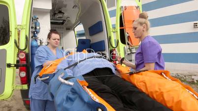 Emergency medical service paramedics female patient on ambulance stretcher