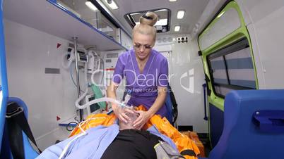 EMT provide emergency medical care for critical senior patient in ambulance