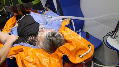 Paramedic monitoring patient condition in ambulance during transportation