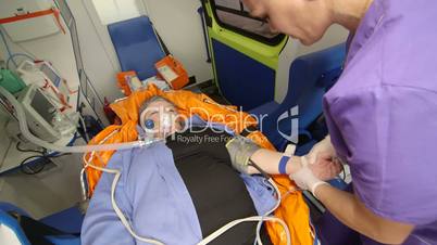 EMT paramedic preparing an intravenous infusion to patient in ambulance