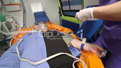 Paramedic provide emergency medical care to patient in ambulance preparing drip