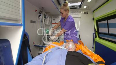 Paramedic provide emergency medical care to patient in ambulance preparing drip