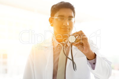 Asian Indian medical doctor holding stethoscope