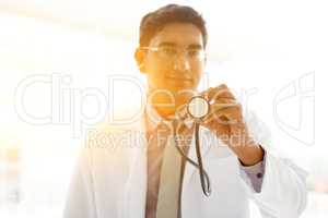 Asian Indian medical doctor holding stethoscope