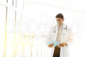 Asian Indian medical doctor reading medical report