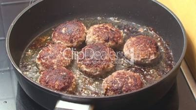 frying the meatballs in hot vegetable oil in a large pan
