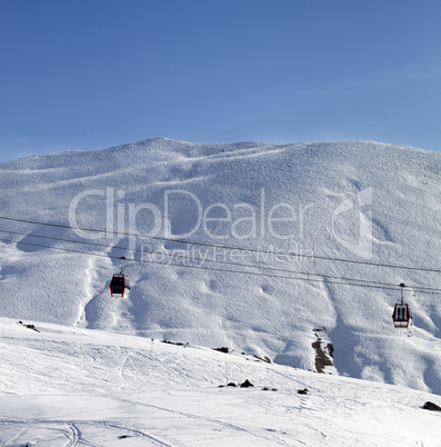 Gondola lifts and ski slope at nice sun morning