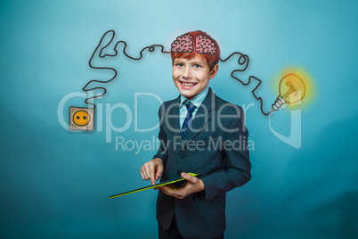 Teenage boy in suit smiling and working in the tablet charging c