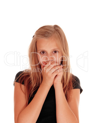 Young girl holding hands over mouth.