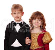 boy in tuxedo and little girl in golden dress posing