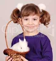 little girl holding a basket with dwarf white bunny