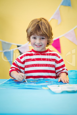 Smiling boy painting a picture