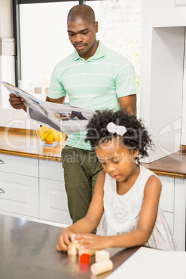 Concentrated father reading newspaper