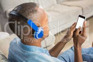 Over shoulder view of casual man listening music