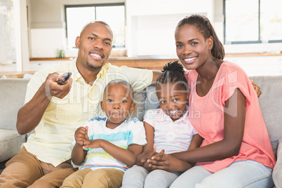 Portrait of a family of four watching tv