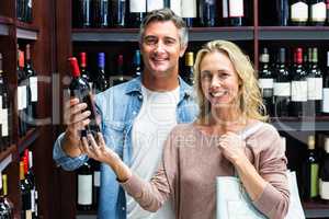 Smiling couple with bottle of wine
