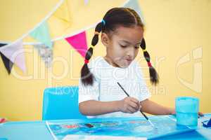 Girl paining a picture on some paper