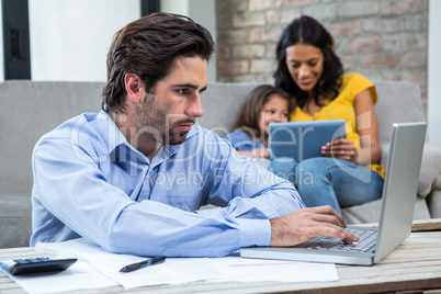 Serious man paying bills in living room