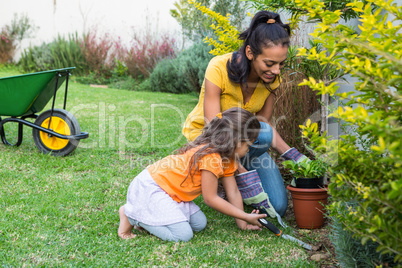 Smiling mother and daughter gardening