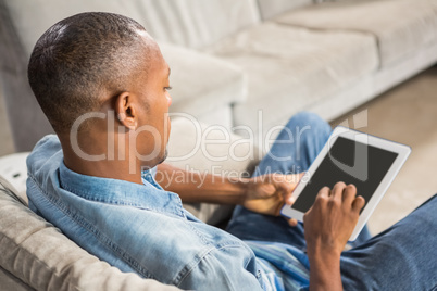 Over shoulder view of casual man using tablet
