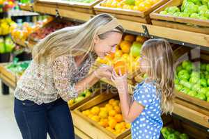 Mother and daughter holding orange