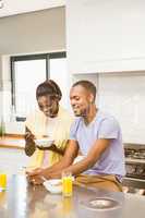 Young couple using tablet at breakfast