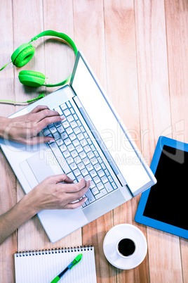 Overhead of feminine hands typing on laptop