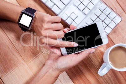 Feminine hands with smartwatch using smartphone