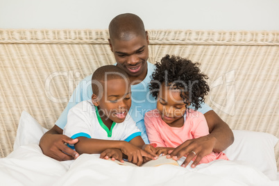 Father reading a book with his children