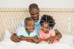 Father reading a book with his children