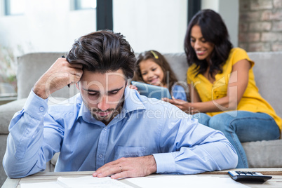 Thoughtful father paying bills in living room