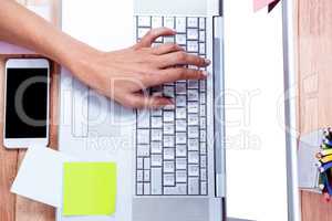 Overhead of feminine hand typing on laptop