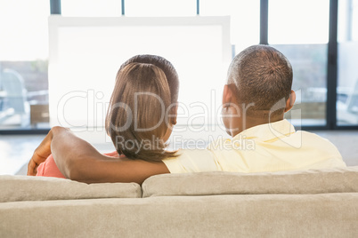 Over shoulder view of casual couple watching tv