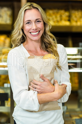 Beautiful woman holding paper bag with bread