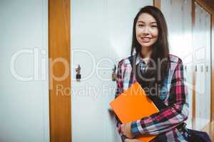 Cheerful student standing next the locker