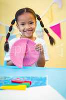 Smiling girl cutting a paper plate
