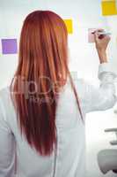 Attractive hipster woman writing on sticky notes