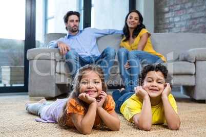Children laying on the carpet in living room