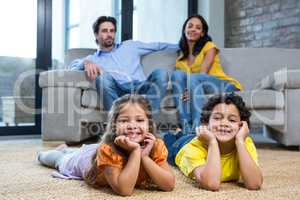 Children laying on the carpet in living room