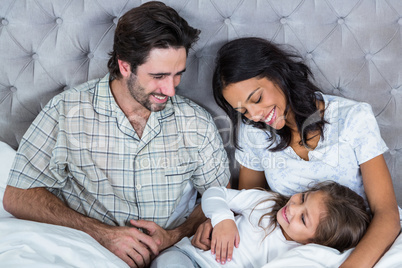 Happy family playing on bed