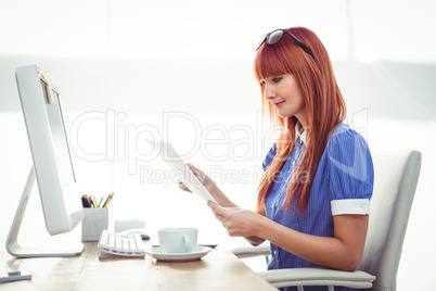 Smiling hipster woman looking at document