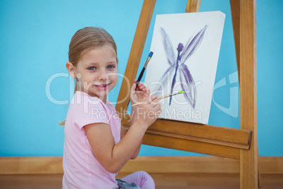 Smiling girl beside her picture