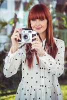 Attractive hipster woman using old fashioned camera