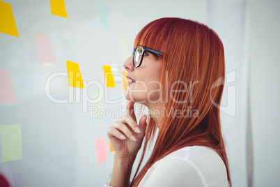 Attractive hipster woman looking at sticky notes