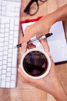 Businesswoman holding black coffee cup