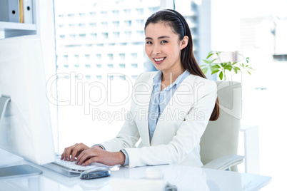 Smiling businesswoman typing on keyboard