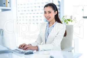 Smiling businesswoman typing on keyboard