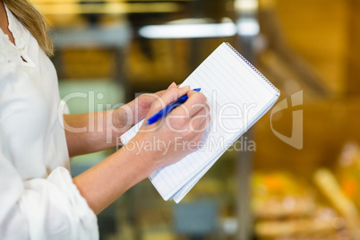 Woman checking list at supermarket