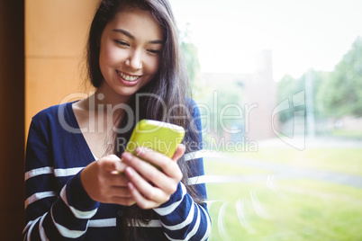 Smiling student using smartphone